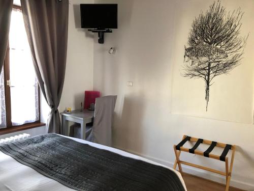 a bedroom with a bed and a chair and a desk at A l'Aube des Volcans in Charbonnières-les-Vieilles