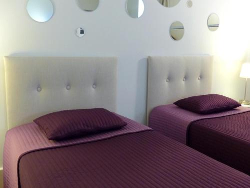 2 łóżka w pokoju z fioletową pościelą w obiekcie La Colombière w mieście Lurcy-le-Bourg
