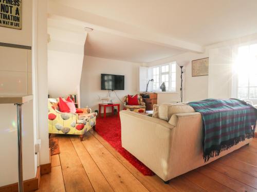 a living room with a couch and a chair at Lantern Cottage in Rye