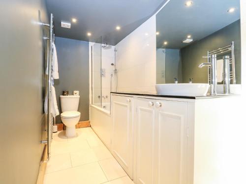 a white bathroom with a sink and a toilet at Lantern Cottage in Rye