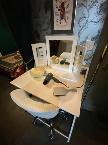 a white desk with a mirror and a chair at Taigh Neonach in Watten