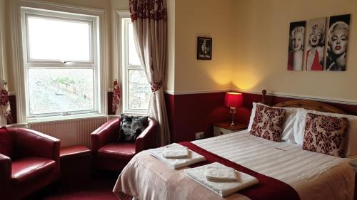 a bedroom with a bed and a dog sitting in a chair at All Seasons Guest House in Great Yarmouth
