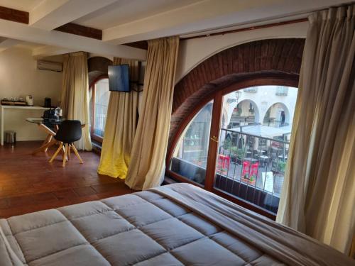 um quarto com uma cama grande e uma janela grande em Suite del Mercante em Mantova