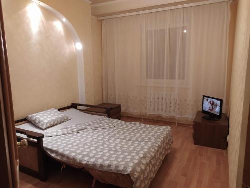 um pequeno quarto com uma cama e uma janela em Двухкомнатная квартира с кухней студией Бровары. em Brovary