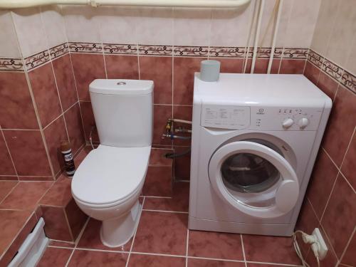 uma casa de banho com um WC e uma máquina de lavar roupa em Двухкомнатная квартира с кухней студией Бровары. em Brovary