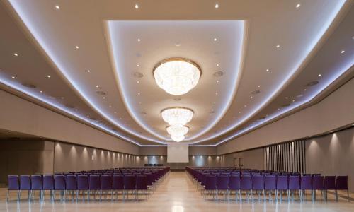 a large room with blue chairs and a large ceiling at InterContinental Barcelona by IHG in Barcelona