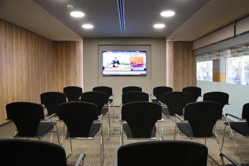 
a room filled with chairs and a projector screen at InterContinental Barcelona, an IHG Hotel in Barcelona
