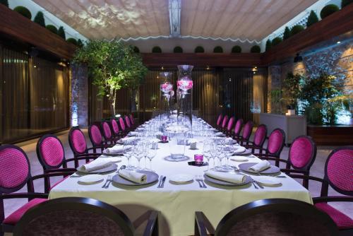 a long table in a room with pink chairs at InterContinental Barcelona by IHG in Barcelona