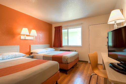 a hotel room with two beds and a flat screen tv at Motel 6-Westminster, CA - South - Long Beach Area in Westminster