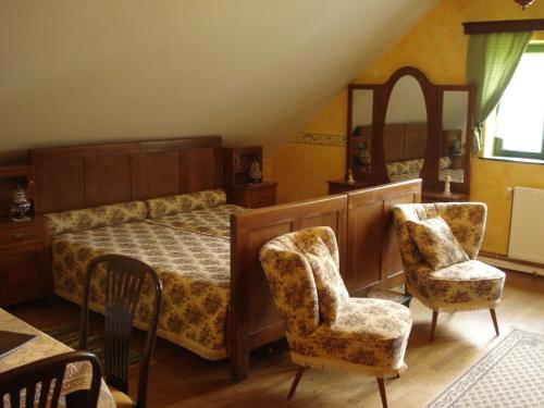 a bedroom with a bed and two chairs at Mikin dol Baranja Country house in Draž