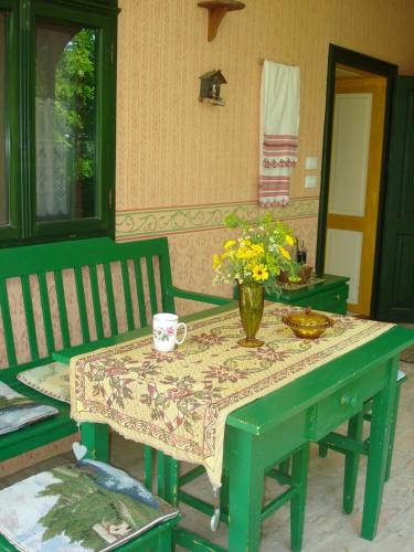 a green table with a vase of flowers on it at Mikin dol Baranja Country house in Draž
