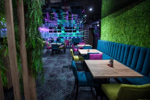 a restaurant with tables and chairs and a green wall at Grand Laola Spa in Pobierowo