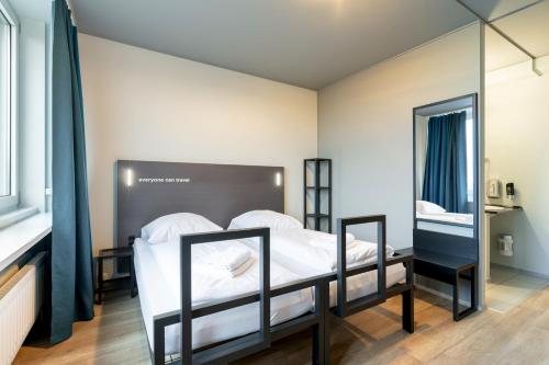 a bedroom with a bed and a mirror at a&o Hamburg Hammer Kirche in Hamburg