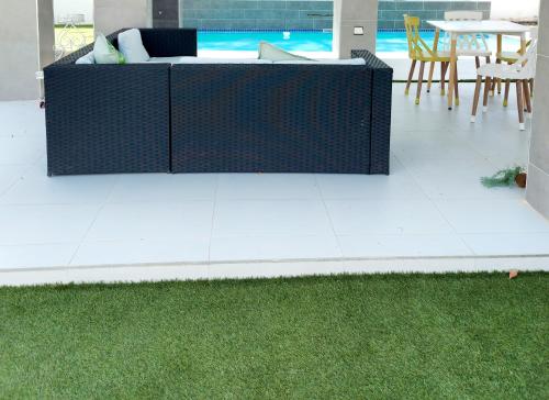 a patio with grass and a couch and a table at Monaco villa Gaborone in Gaborone