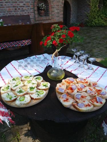 three pizzas on a table with wine glasses and flowers at Mikin dol Baranja Country house in Draž