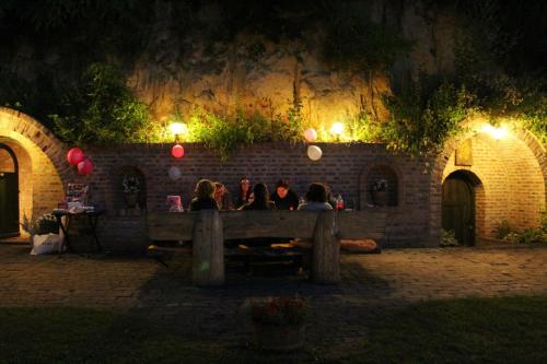 a group of people sitting on a bench at night at Mikin dol Baranja Country house in Draž