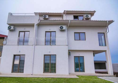 a white house with windows and a balcony at Casa AdiMan in Vama Veche