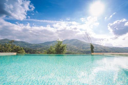 a large swimming pool with mountains in the background at Casas da Fraga 2020 in Ribeira de Pena