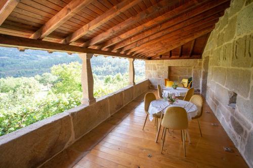 ein Esszimmer mit Tisch und Stühlen auf einem Balkon in der Unterkunft Casas da Fraga 2020 in Ribeira de Pena