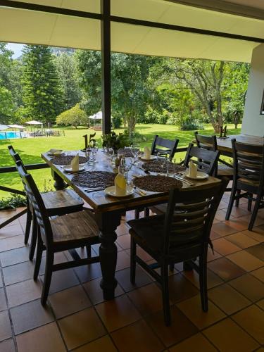 a wooden table and chairs on a patio at Avoca Vale Country Hotel in Louis Trichardt