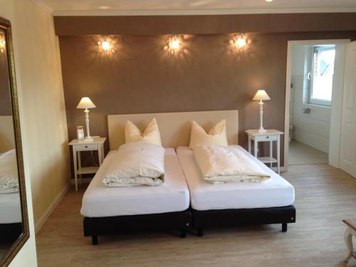 a bedroom with two beds with white sheets and pillows at Landhotel Franck Garni in Brietlingen