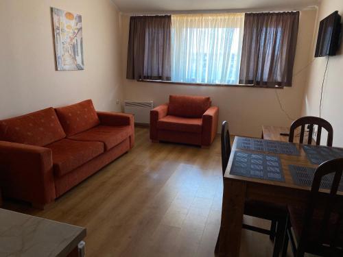 a living room with a couch and a chair at CEDAR LODGE NEXT TO LIFT ONE BEDROOM APARTMENT in Bansko