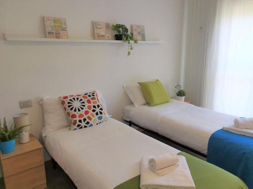 Zimmer mit 2 Betten und einem Sofa in der Unterkunft Bnbook Trilo Mind Rho Trilocale con 2 camere e 2 bagni in Rho