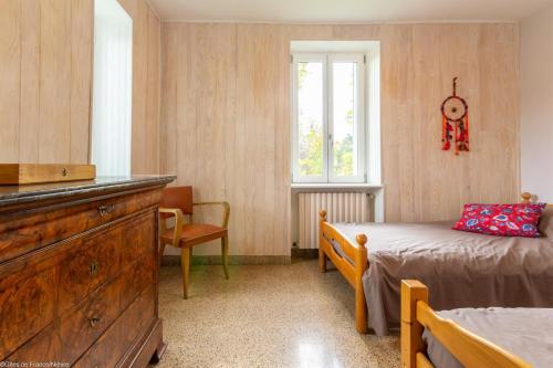a bedroom with a bed and a dresser and a window at Gîte du Verger in Onlay