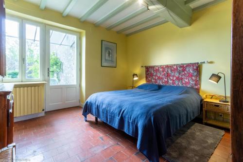 una camera con letto e copriletto blu di Gîte du Verger a Onlay