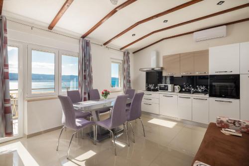 a kitchen with a dining room table and chairs at Azra Apartments in Duće