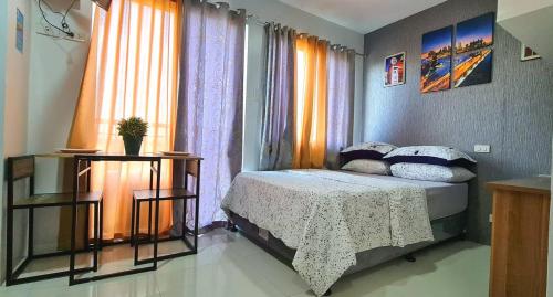 a small bedroom with a bed and a window at 913Cityscape located at city center in Bacolod