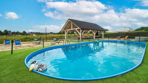 a large pool in a park with a gazebo at Resorts H Białka Tatrzańska z sauną, Sun & Snow in Białka Tatrzanska