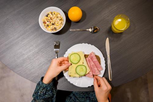 a person holding a plate of food with meat and vegetables at a&o Hamburg Hammer Kirche in Hamburg