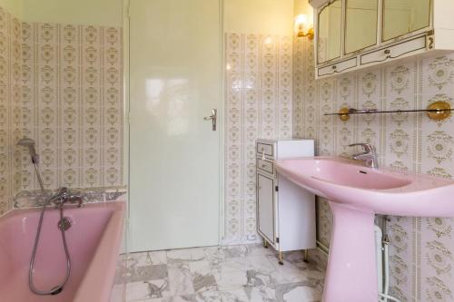 a pink bathroom with a sink and a tub at Le Clos de Tweed in Tanlay