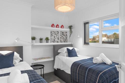 a bedroom with two beds and a window at MyCityHaven - The Grove. Superb house sleeps 8 in Avonmouth