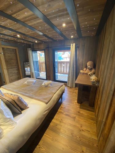 a bedroom with a bed and a teddy bear on a table at Les Mazots des Fées in Morzine