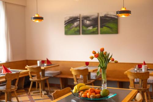a dining room with a table with a bowl of fruit at Hotel Bären Niederscherli in Niederscherli