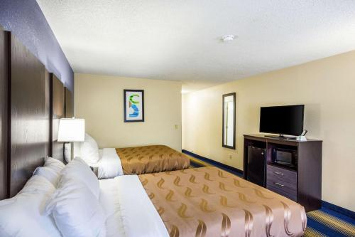 a hotel room with two beds and a flat screen tv at Quality Inn Charleston South in Charleston