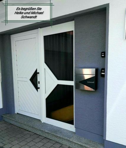 a white garage door with a window on a building at Ferienwohnungen Hochgrebe in Kleinern