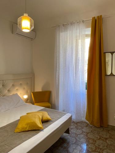a bedroom with a bed with a yellow pillow on it at BIANCA ROOMS in Noto