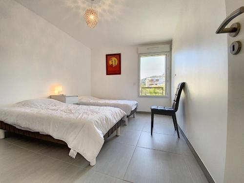 - 2 lits dans une chambre avec une chaise et une fenêtre dans l'établissement Montfleurie TEI142 3P, à Cannes