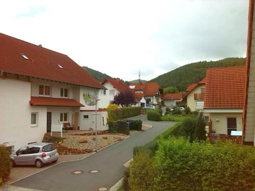 Vistas a una calle residencial con casas y un coche en Ferienwohnungen Hochgrebe, en Kleinern