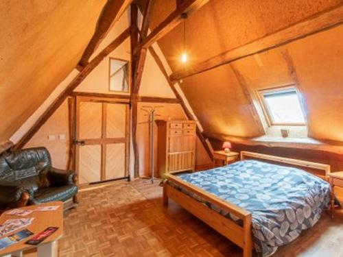 a bedroom with a bed and a chair in a attic at LES GRANGES D'ANTAN - La FORGE - in Chalonnes-sous-le-Lude