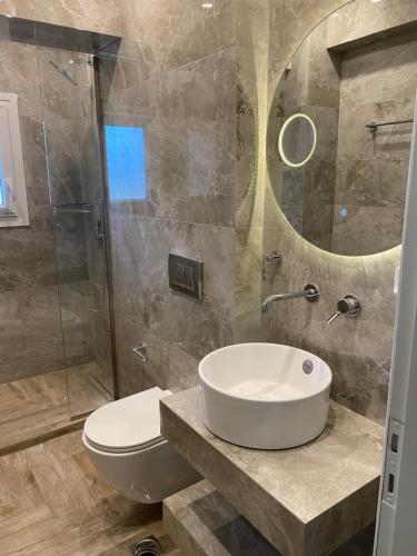 a bathroom with a sink and a toilet and a shower at Athinais LAK Villa in Lakithra