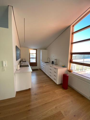 a kitchen with white cabinets and a large window at Reykjavík Central Apartments in Reykjavík