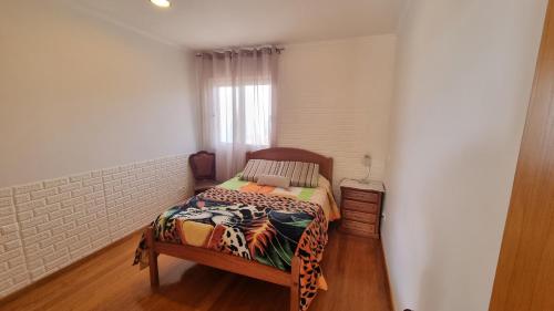 a small bedroom with a bed and a window at Loreto Rose, Panoramic Ocean and Mountain View in Arco da Calheta