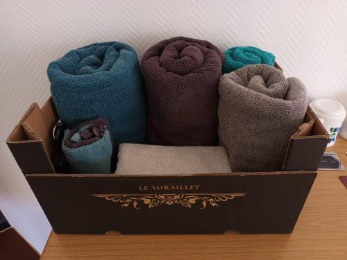 a box filled with different colored towels on a table at Le Miraillet, chambre hôte in Saint-Illide
