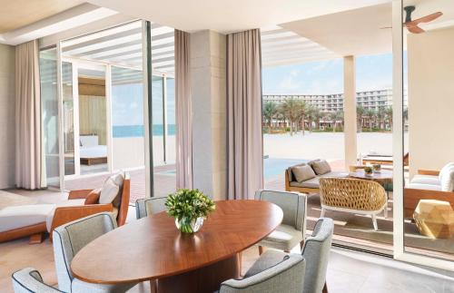 a dining room with a table and chairs and the beach at InterContinental Ras Al Khaimah Resort and Spa, an IHG Hotel in Ras al Khaimah