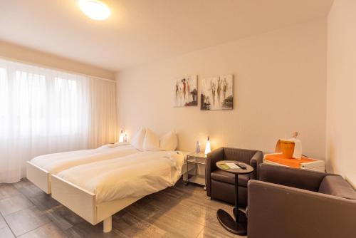 a hotel room with a bed and a chair at Hotel Bären Niederscherli in Niederscherli
