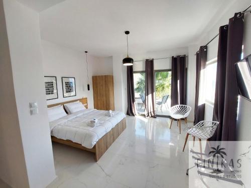 a bedroom with a bed and a table and chairs at Finikas Suites & Apartments Airport By Airstay in Artemida